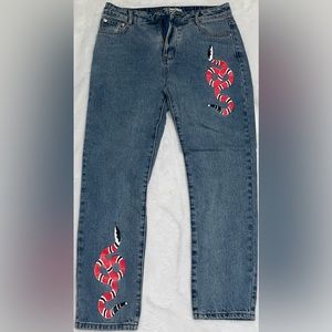 Adika mom jeans with snakes. size large, will fit between a size 4-6.